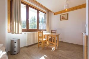 a room with a table and chairs and a window at Résidence La Grande Cordée - Combloux in Combloux