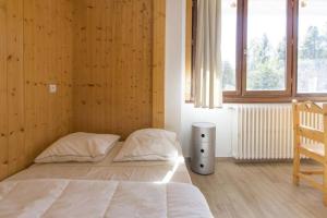 a bedroom with a bed and a wooden wall at Résidence La Grande Cordée - Combloux in Combloux