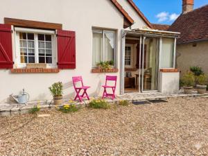 a house with two pink chairs on a patio at Caporizon - La Solognote in Bracieux