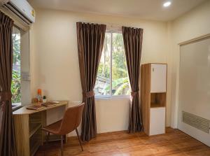 a room with a desk and a window at Casa Srithanu in Ko Phangan