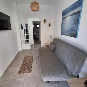a living room with a couch and a television at Sky Rooms in Nea Kallikrateia