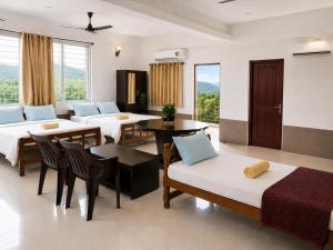 a room with two beds and a table and chairs at THE MOUNT VIEW CASTLE HOTELS and RESORTS in Tenkāsi