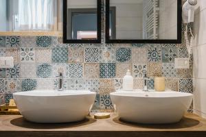 a bathroom with two sinks and a mirror and tiles at Dimora Marinucci in Termoli +28 photos
