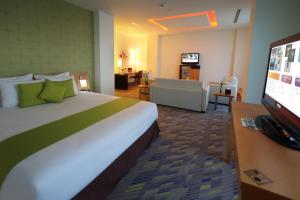 a hotel room with a large bed and a living room at Novotel Dammam Business Park in Dammam