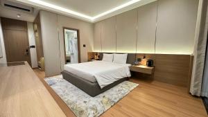 a bedroom with a white bed and a rug at The Villas Hotel in Pleiku