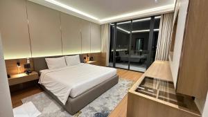 a bedroom with a large white bed and a living room at The Villas Hotel in Pleiku