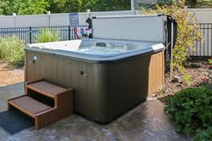 a hot tub with a bench in a yard at Inn Like a Lamb in South Haven