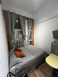a small bedroom with a bed and a window at VOY Hostales - Poniente in Viña del Mar