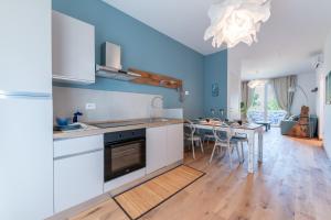 a kitchen with white cabinets and a table with chairs at In Riva in Cavallino-Treporti