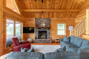 a living room with a couch and a fireplace at Chasing Clouds Cabin in Todd