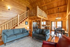 a living room with two couches and a staircase at Chasing Clouds Cabin in Todd