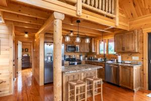 a large kitchen with wooden walls and wooden floors at Chasing Clouds Cabin in Todd +37 photos