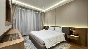 a bedroom with a large bed and a large window at The Villas Hotel in Pleiku