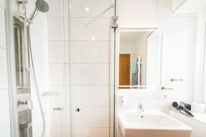 a white bathroom with a sink and a shower at Hotel Pension Barbara in Sankt Martin am Tennengebirge