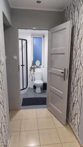 a bathroom with a white toilet and a door at Horiza in Gdańsk