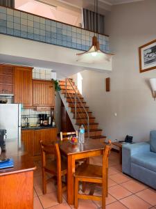 a kitchen and dining room with a table and a couch at Apartamentos Turisticos Verdemar in Horta