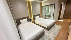 a hotel room with two beds and a bathroom at The Villas Hotel in Pleiku +14 photos