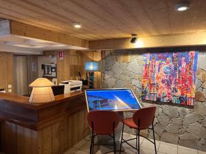 a bar with two chairs and a laptop on a counter at Logis Hôtel Le Cairn in Les Deux Alpes