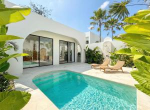 a swimming pool in front of a house at The Young Villas - 1 Bedroom Villas, Bingin in Uluwatu