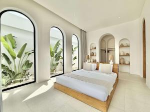 a bedroom with a large bed with large windows at The Young Villas - 1 Bedroom Villas, Bingin in Uluwatu +28 photos