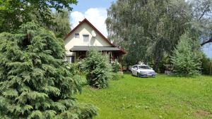 a house with a car parked in a yard with a christmas tree at Ferienhaus Schlothauer 1 in Tiszacsege