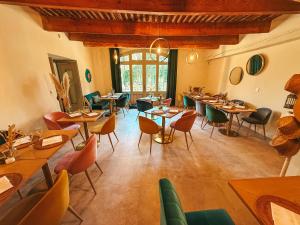 a restaurant with tables and chairs in a room at Le Domaine des Grès Luberon - Hôtel - Restaurant Sous les Platanes - Restaurant 901 côté piscine in Lagnes