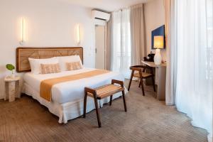 a hotel room with a large bed and a desk at Crisol Lumière in Cannes