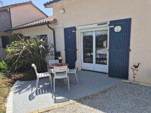 a patio with a table and chairs in front of a house at Gîte de la Lorada in Nouaillé-Maupertuis