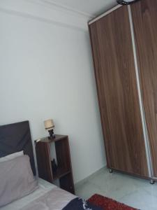 a bedroom with a bed and a large wooden closet at Cozy two bedroom apartment in Meknès +4 photos