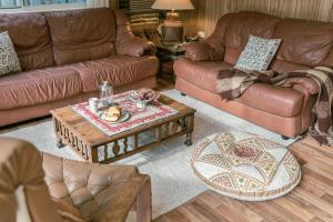 a living room with leather couches and a coffee table at Sugar Shack Currarong in Currarong