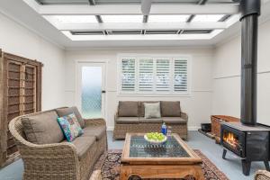 a living room with a couch and a fireplace at Sugar Shack Currarong in Currarong +27 photos