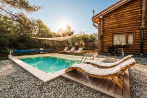a pool with a chair and a house at Holzhaus in Sadu