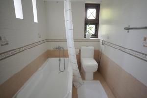 a bathroom with a toilet and a bath tub at Casa by Cosy Concept in Trivandrum