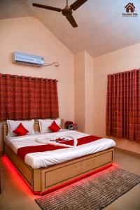 a bedroom with a large bed with red curtains at CHOCOLATE VILLA Mahabaleshwar in Mahabaleshwar +31 photos