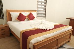 a bedroom with a large white bed with red pillows at Casa by Cosy Concept in Trivandrum