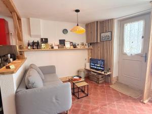 a living room with a couch and a television at La maison du père Bellessort in Régnié