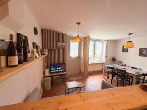 a room with a dining room with a table with wine bottles at La maison du père Bellessort in Régnié