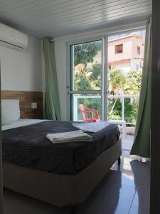 a bedroom with a bed and a large window at Pousada Porto Amazônia in Porto De Galinhas +91 photos