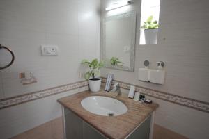 a bathroom with a sink and a mirror at Casa by Cosy Concept in Trivandrum