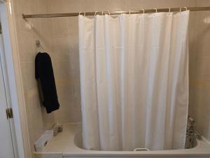 a white shower curtain in a bathroom with a tub at Alex in Castlerea +16 photos