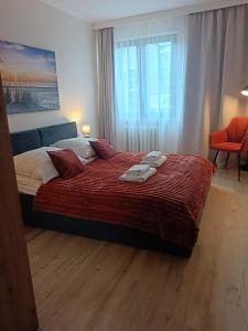 a bedroom with a large bed with two towels on it at Morski Klimat in Jastrzębia Góra