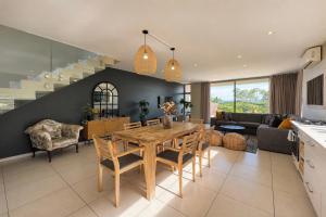 a kitchen and living room with a wooden table and chairs at Ballito Zimbali Wedge in Ballito