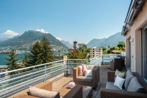 ein Balkon mit Möbeln und Blick auf die Berge in der Unterkunft Suitenhotel Parco Paradiso in Lugano