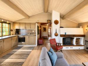 a living room with a couch and a fireplace at Briskebu, cosy cabin by ski slopes in Geilo