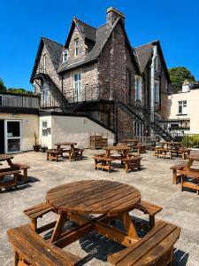 a group of wooden picnic tables in front of a building at The Burlington Hotel in Torquay