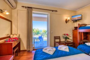 ein Schlafzimmer mit zwei Betten und Balkon in der Unterkunft Sunset Hotel in Korfu-Stadt