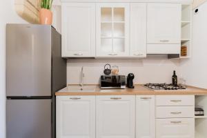 a kitchen with white cabinets and a refrigerator at Melodia del Salento - Lecce Selection in Surbo