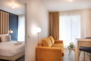 a bedroom with a bed and a couch and a chair at Ibis Styles Paris Pont d'Ivry in Ivry-sur-Seine