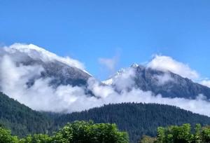 a mountain with clouds in front of it at Hotel Gulsar pahalgam in Pahalgām