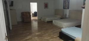 ein Wohnzimmer mit zwei Betten und Holzboden in der Unterkunft Casa Ivana in Guayaquil